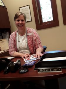image shows woman sitting at desk.